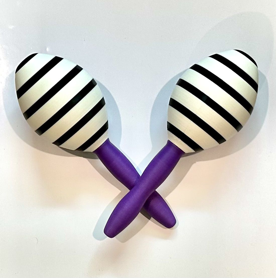 A pair of striped 3D-printed maracas with purple handles.