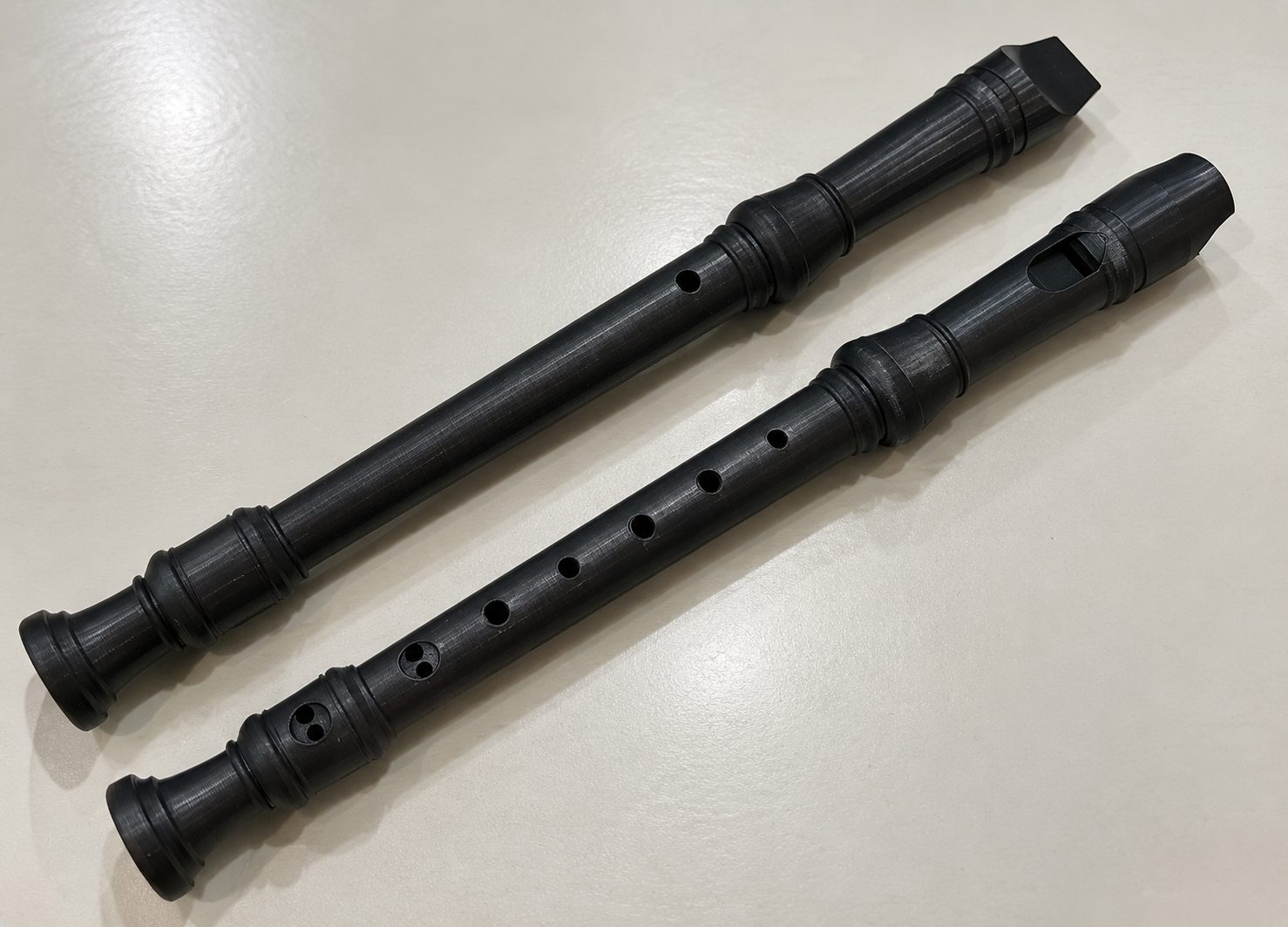 Two black 3D-printed recorders