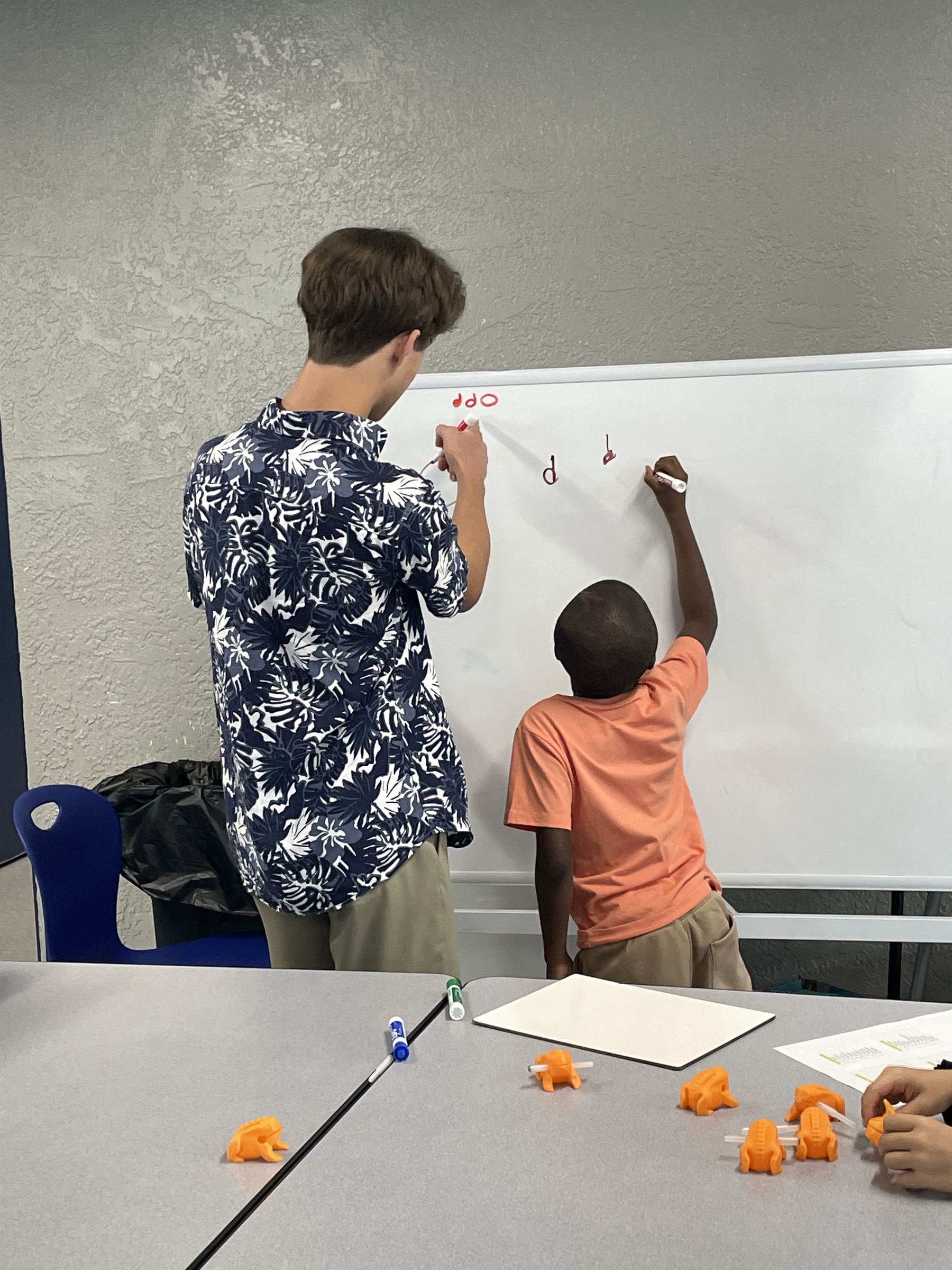 A mentor and student writing music notation together.